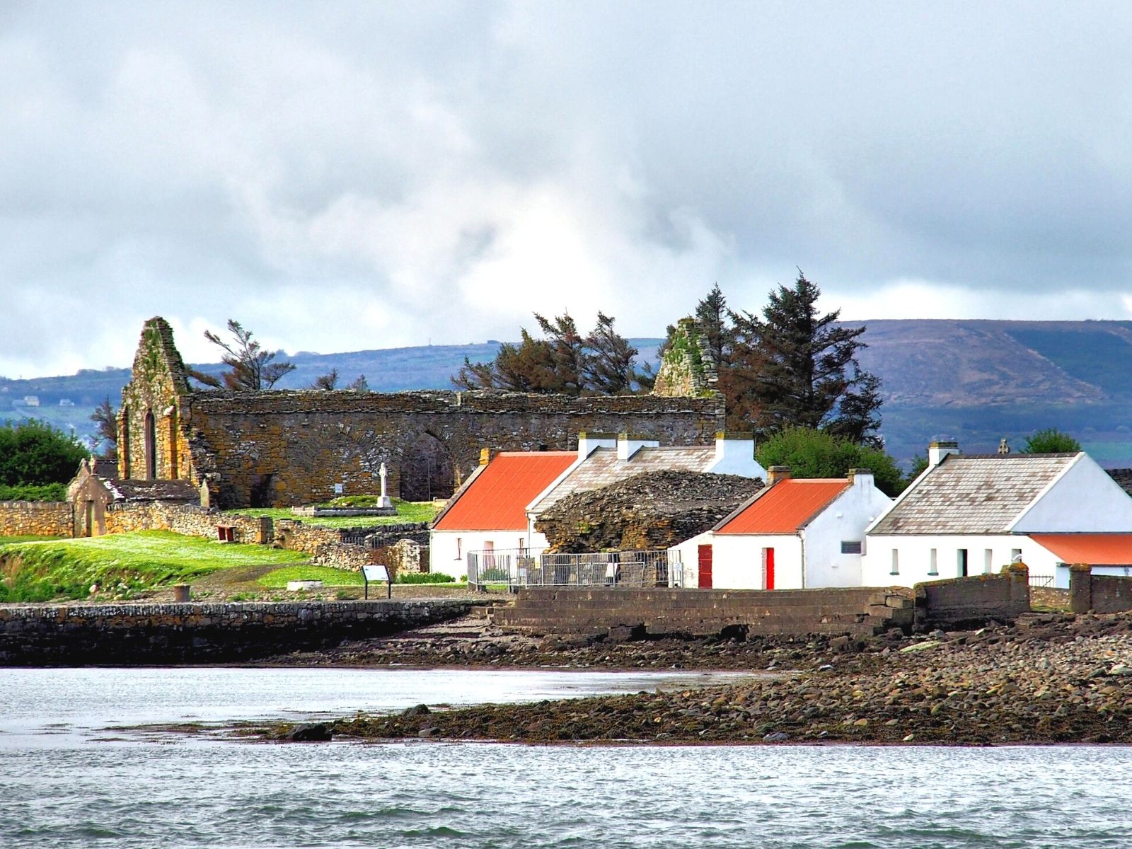 The shoreline on Scattery Island with island cottages and Teampeal na Marbh